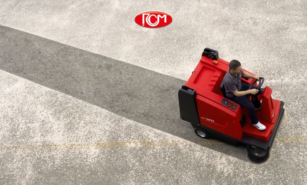 Floor cleaning machine maintenance, person driving a street sweeper in a commerical area