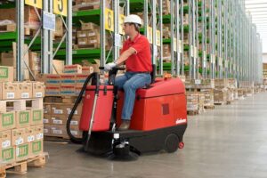 warehouse cleaning - red ride on sweeper
